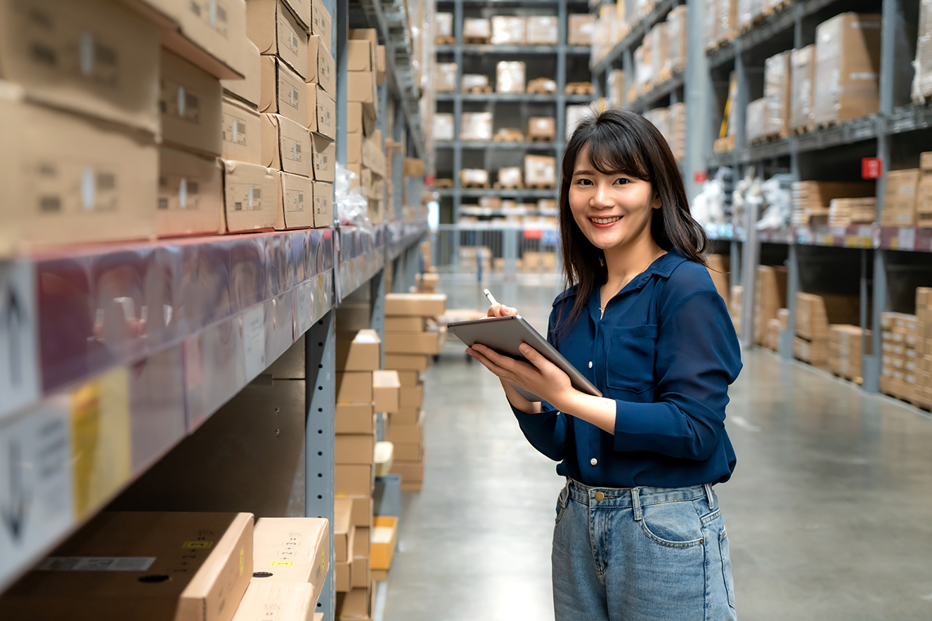Manufacturing employee holding a tablet and metal part on a shop floor