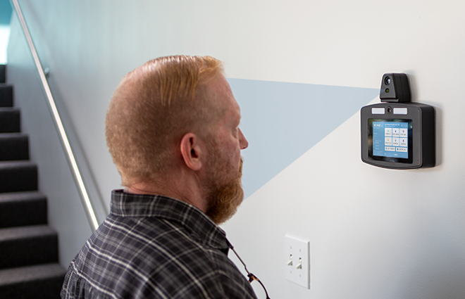 Employee clocking in with a facial recognition time clock system