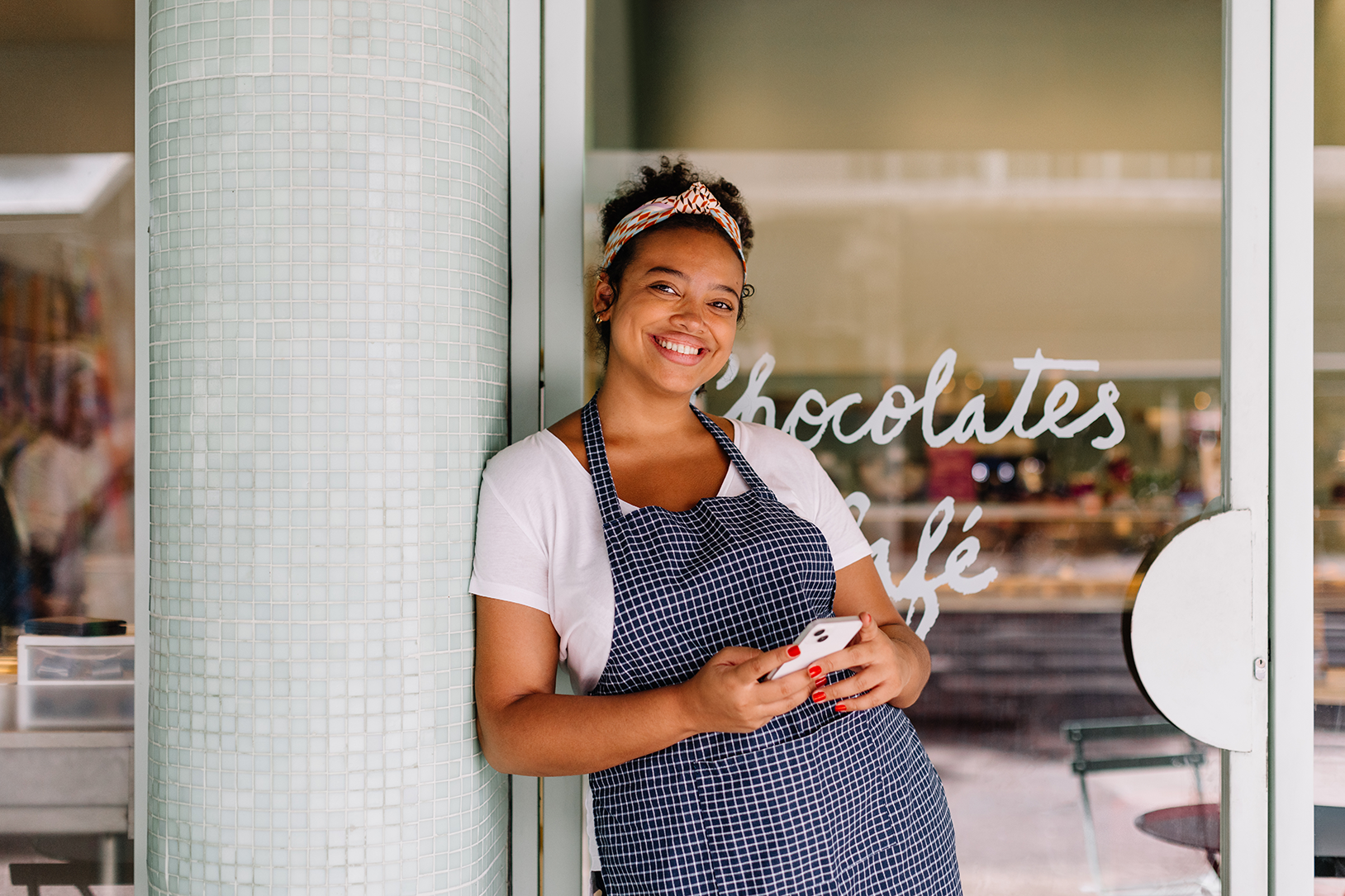 Bakery owner checking time and attendance on her phone