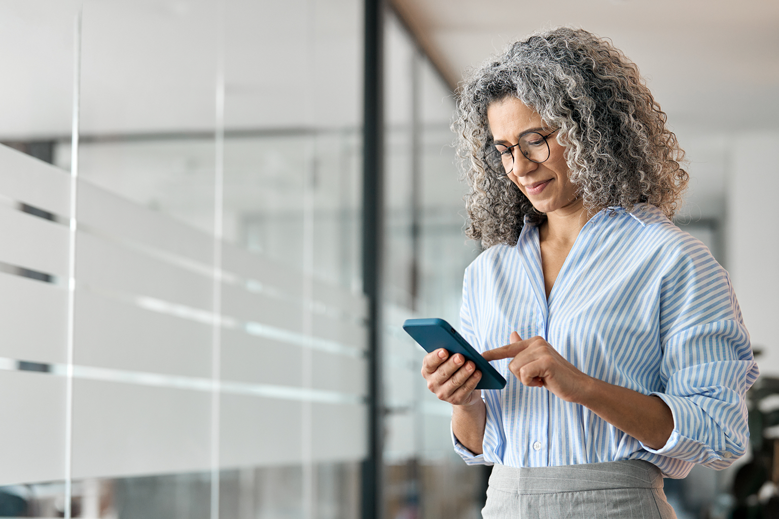 Office manager checking workforce scheduling on her phone